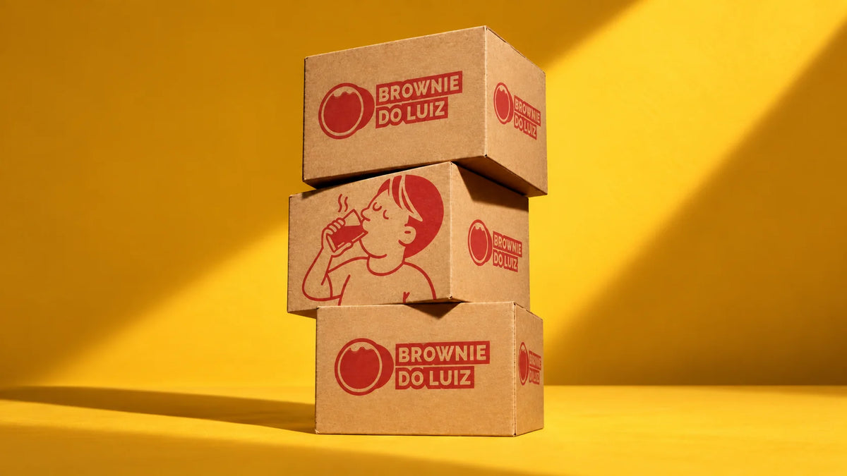 Três caixas do Brownie do Luiz empilhadas sobre fundo amarelo